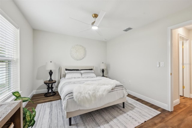 bedroom featuring baseboards, wood finished floors, and ceiling fan