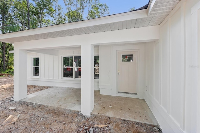 property entrance featuring board and batten siding and a patio area