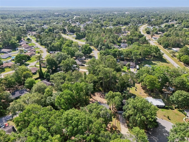 view of property location with nearby suburban area and a forest