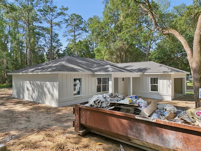 back of property featuring a shingled roof and board and batten siding