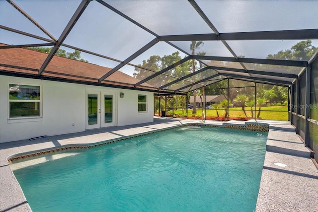 outdoor pool with french doors, a patio area, and glass enclosure