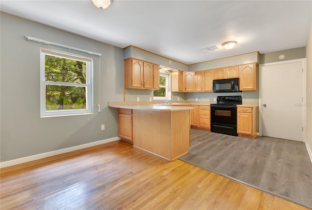 12046 SE 135th Ave, Ocklawaha, FL 32179 - kitchen featuring black appliances, light wood-style flooring, light countertops, a peninsula, and baseboards