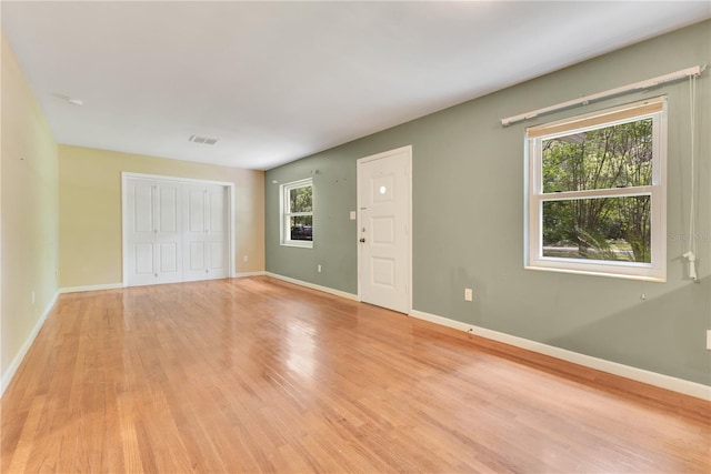 12046 SE 135th Ave, Ocklawaha, FL 32179 - empty room with light wood-style flooring, healthy amount of natural light, and baseboards