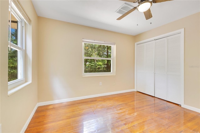 12046 SE 135th Ave, Ocklawaha, FL 32179 - unfurnished bedroom featuring light wood-style floors, baseboards, a closet, and a ceiling fan