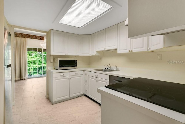 200 Maitland Ave Unit 122, Altamonte Springs, FL 32701 - kitchen featuring stainless steel microwave, a sink, light countertops, black electric cooktop, and white cabinetry