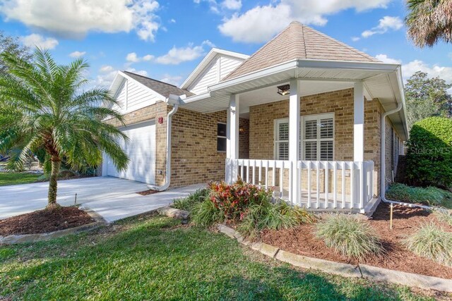 25 Reflections Village Dr, Ormond Beach, FL 32174 - view of front of property with covered porch, a garage, concrete driveway, and brick siding