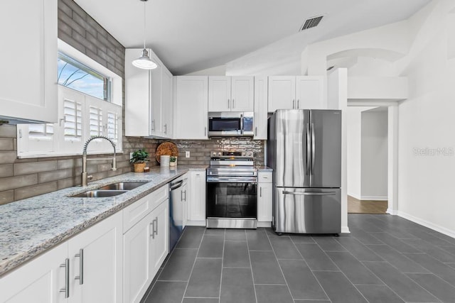 25 Reflections Village Dr, Ormond Beach, FL 32174 - kitchen with appliances with stainless steel finishes, a sink, white cabinets, and vaulted ceiling