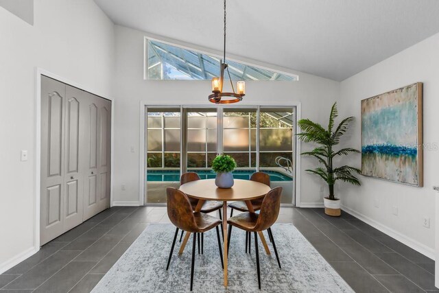 25 Reflections Village Dr, Ormond Beach, FL 32174 - dining area featuring a chandelier, high vaulted ceiling, dark tile patterned floors, and baseboards