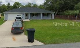 ranch-style house with concrete driveway, a front lawn, and a garage