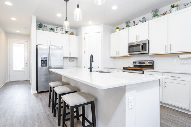 200 Summershore Dr, Auburndale, FL 33823 - kitchen featuring appliances with stainless steel finishes, a sink, light wood-style floors, a breakfast bar, and recessed lighting