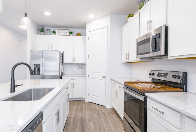 200 Summershore Dr, Auburndale, FL 33823 - kitchen with stainless steel appliances, a sink, light wood-style flooring, white cabinets, and recessed lighting