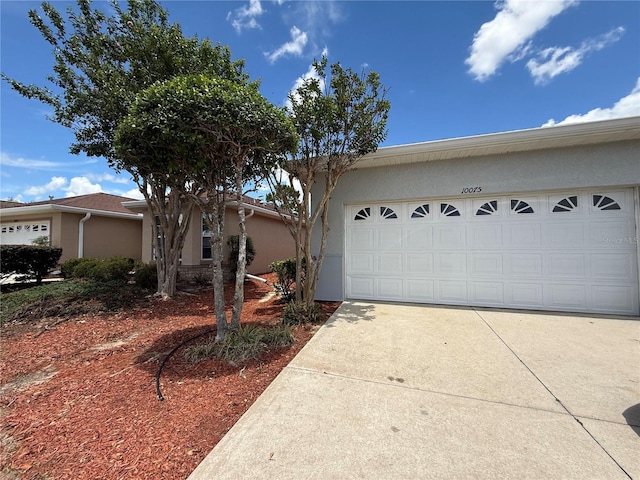 10075 SW 91st Pl, Ocala, FL 34481 - view of front of property with stucco siding, concrete driveway, and an attached garage