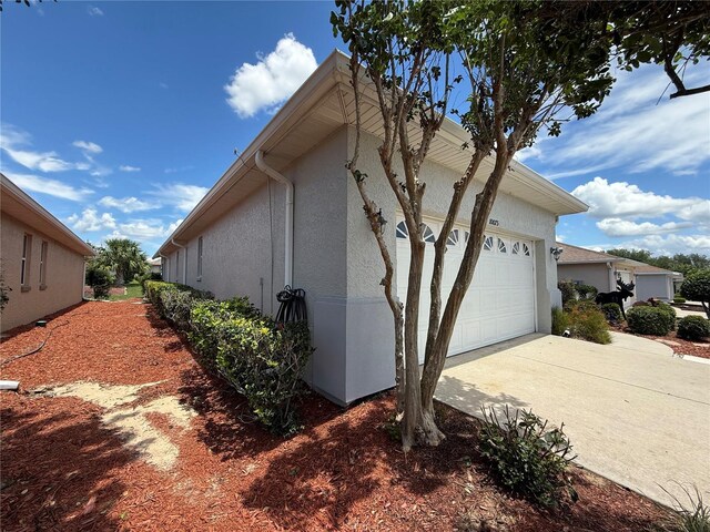 10075 SW 91st Pl, Ocala, FL 34481 - view of property exterior with driveway, stucco siding, and a garage