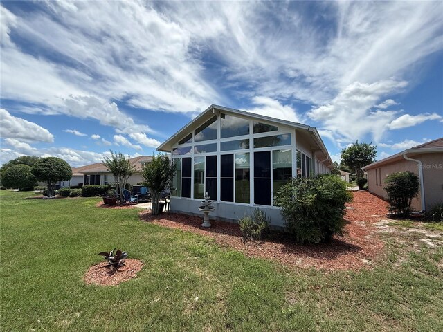10075 SW 91st Pl, Ocala, FL 34481 - rear view of house with a sunroom and a lawn