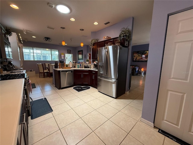 10075 SW 91st Pl, Ocala, FL 34481 - kitchen featuring appliances with stainless steel finishes, a peninsula, light countertops, dark brown cabinets, and decorative light fixtures
