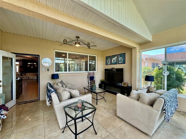 10075 SW 91st Pl, Ocala, FL 34481 - living area featuring light tile patterned floors, beamed ceiling, a ceiling fan, and a textured wall