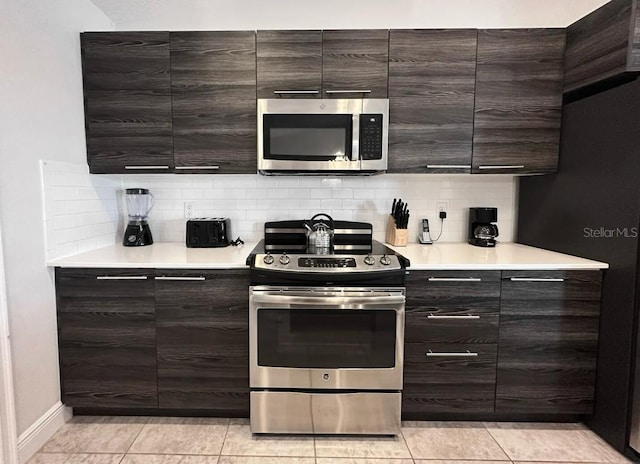 145 Kenny Blvd, Haines City, FL 33844 - kitchen with stainless steel appliances, backsplash, light countertops, and dark brown cabinets