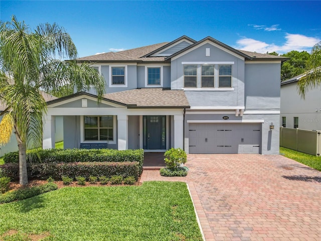 view of front facade with stucco siding, an attached garage, decorative driveway, and a shingled roof