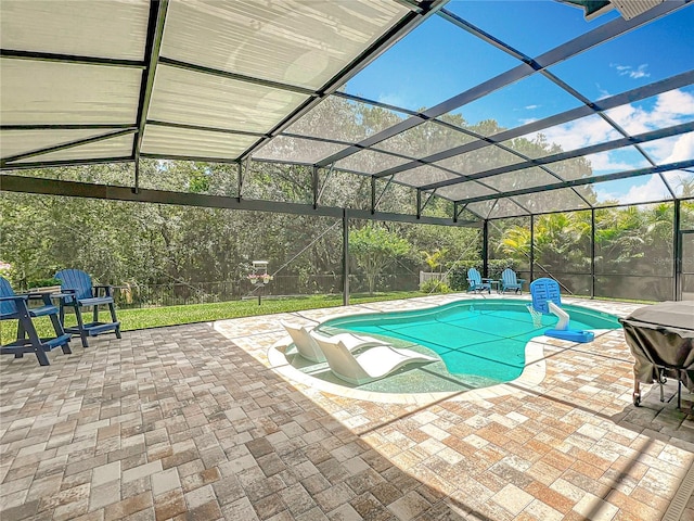 outdoor pool featuring a patio area and glass enclosure