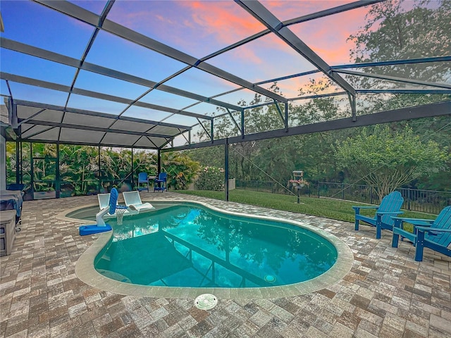 swimming pool featuring a patio, glass enclosure, and a yard