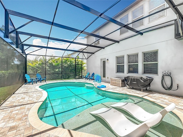 outdoor pool featuring a patio area and glass enclosure