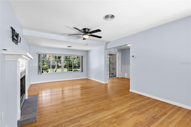 360 W University Ave, Orange City, FL 32763 - unfurnished living room with a fireplace, light wood-style flooring, ceiling fan, and baseboards