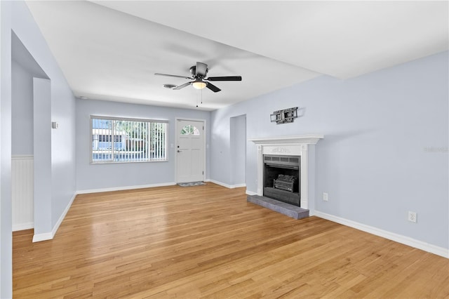 360 W University Ave, Orange City, FL 32763 - unfurnished living room with a brick fireplace, light wood finished floors, a ceiling fan, and baseboards