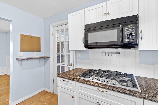 360 W University Ave, Orange City, FL 32763 - kitchen with black microwave, stainless steel gas cooktop, and white cabinetry