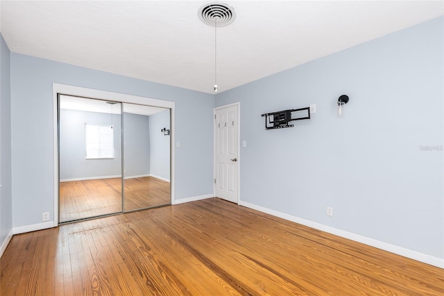 360 W University Ave, Orange City, FL 32763 - unfurnished bedroom featuring hardwood / wood-style floors, baseboards, and a closet