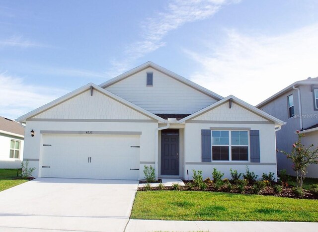view of front of home with a garage, concrete driveway, and a front lawn