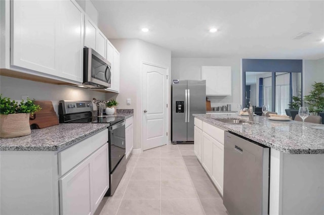 kitchen with stainless steel appliances, a sink, an island with sink, white cabinetry, and recessed lighting