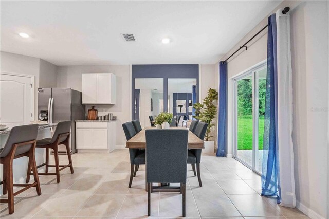 dining room featuring baseboards, light tile patterned floors, and recessed lighting