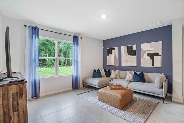 living area featuring baseboards and light tile patterned floors