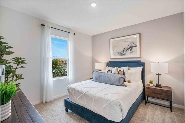 bedroom featuring light carpet and baseboards
