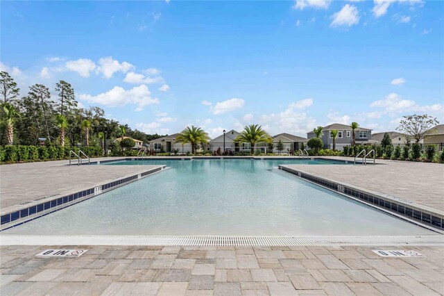 community pool with a patio and a residential view