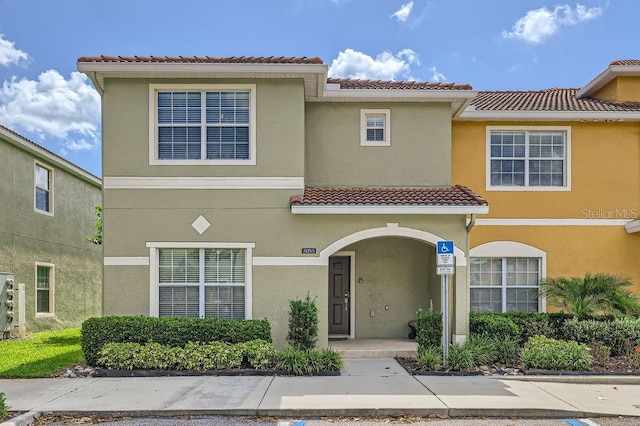 3055 Beach Palm Ave, Kissimmee, FL 34747 - townhome / multi-family property with a tile roof, stucco siding, and a porch