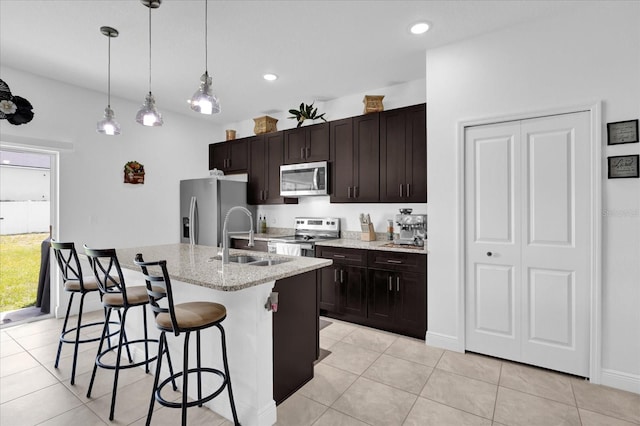 606 Marion Oaks Blvd, Ocala, FL 34473 - kitchen featuring appliances with stainless steel finishes, a sink, a breakfast bar area, a kitchen island with sink, and light tile patterned flooring