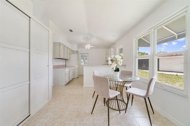 1243 Tangerine Cir, Lady Lake, FL 32159 - dining space featuring light tile patterned floors, vaulted ceiling, a ceiling fan, and baseboards