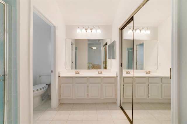 1243 Tangerine Cir, Lady Lake, FL 32159 - full bathroom with double vanity, tile patterned flooring, toilet, and a shower stall