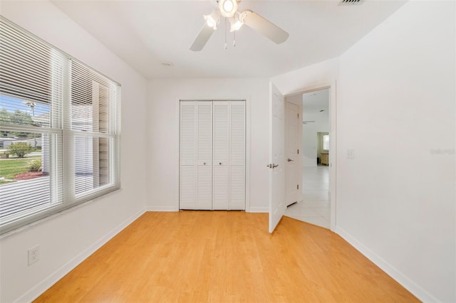 1243 Tangerine Cir, Lady Lake, FL 32159 - unfurnished bedroom with light wood-style flooring, a closet, baseboards, and ceiling fan