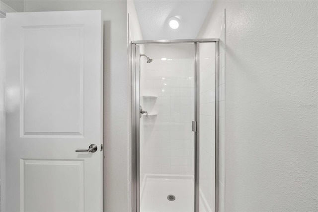 1128 Challenge Dr, Davenport, FL 33896 - bathroom featuring a stall shower and a textured wall