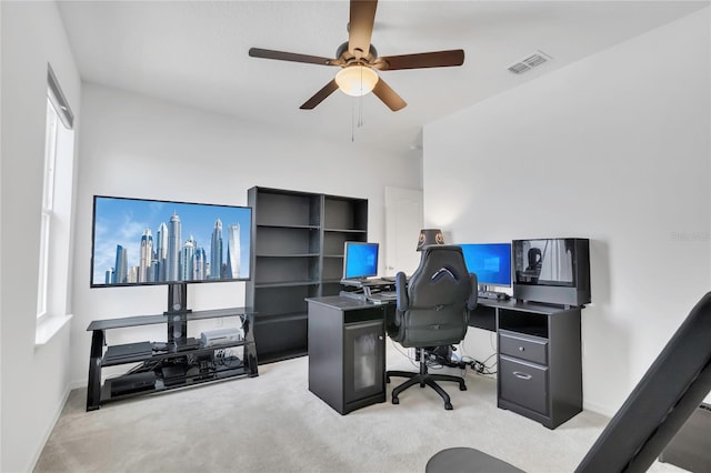 office space featuring light carpet, ceiling fan, and baseboards