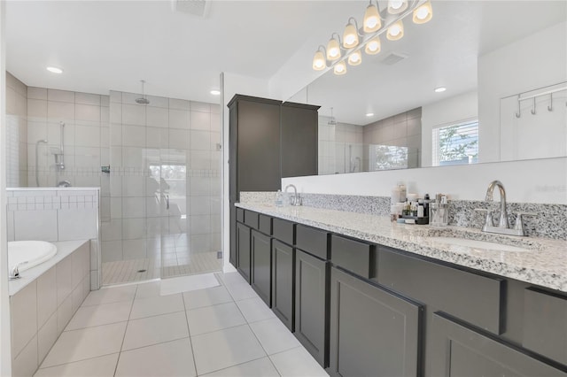 full bathroom with a tile shower, tile patterned floors, a bath, and double vanity