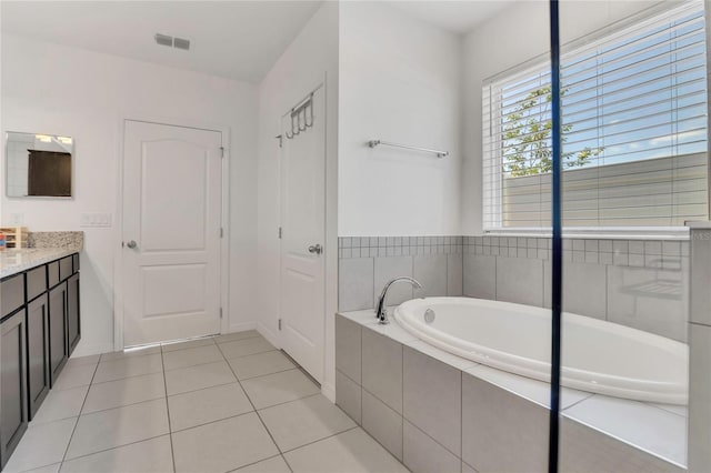 bathroom featuring a garden tub, tile patterned floors, and vanity