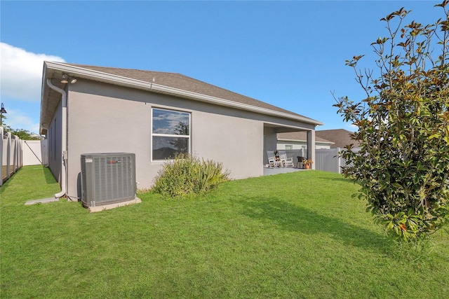 rear view of house with central AC unit and stucco siding