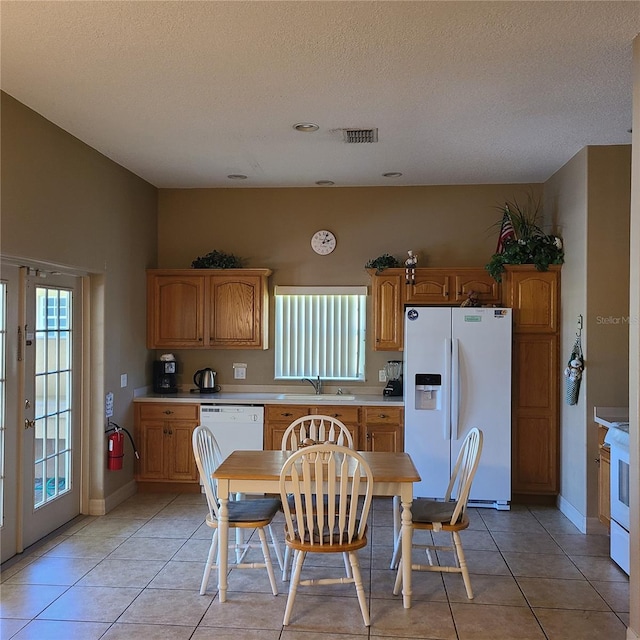 225 Vista Dr, Davenport, FL 33897 - kitchen with white appliances, light countertops, light tile patterned floors, a textured ceiling, and baseboards