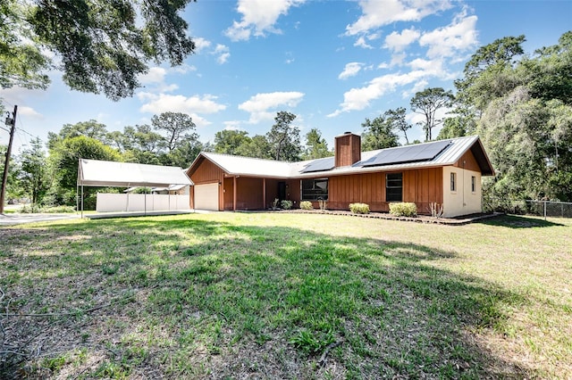 175 Cliff St, Deland, FL 32720 - rear view of house with a chimney, an attached garage, and solar panels