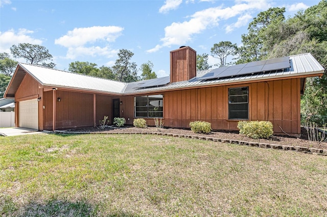 175 Cliff St, Deland, FL 32720 - view of front of house with an attached garage, a chimney, metal roof, solar panels, and board and batten siding