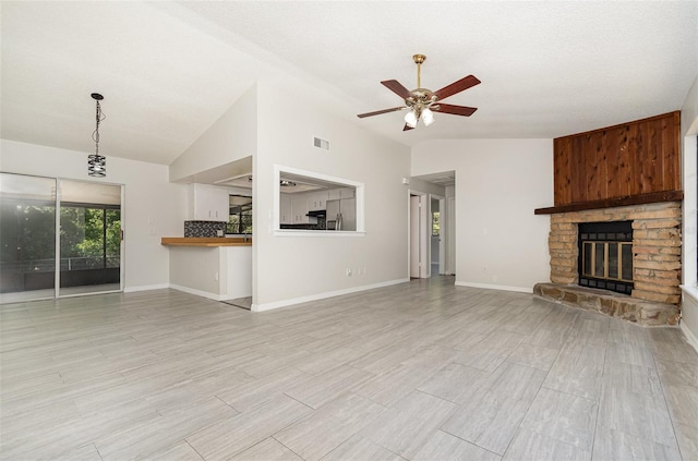 175 Cliff St, Deland, FL 32720 - unfurnished living room featuring a ceiling fan, a stone fireplace, lofted ceiling, light wood-style floors, and baseboards