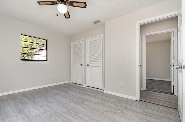 175 Cliff St, Deland, FL 32720 - unfurnished bedroom with light wood-style floors, baseboards, a ceiling fan, a closet, and a textured ceiling